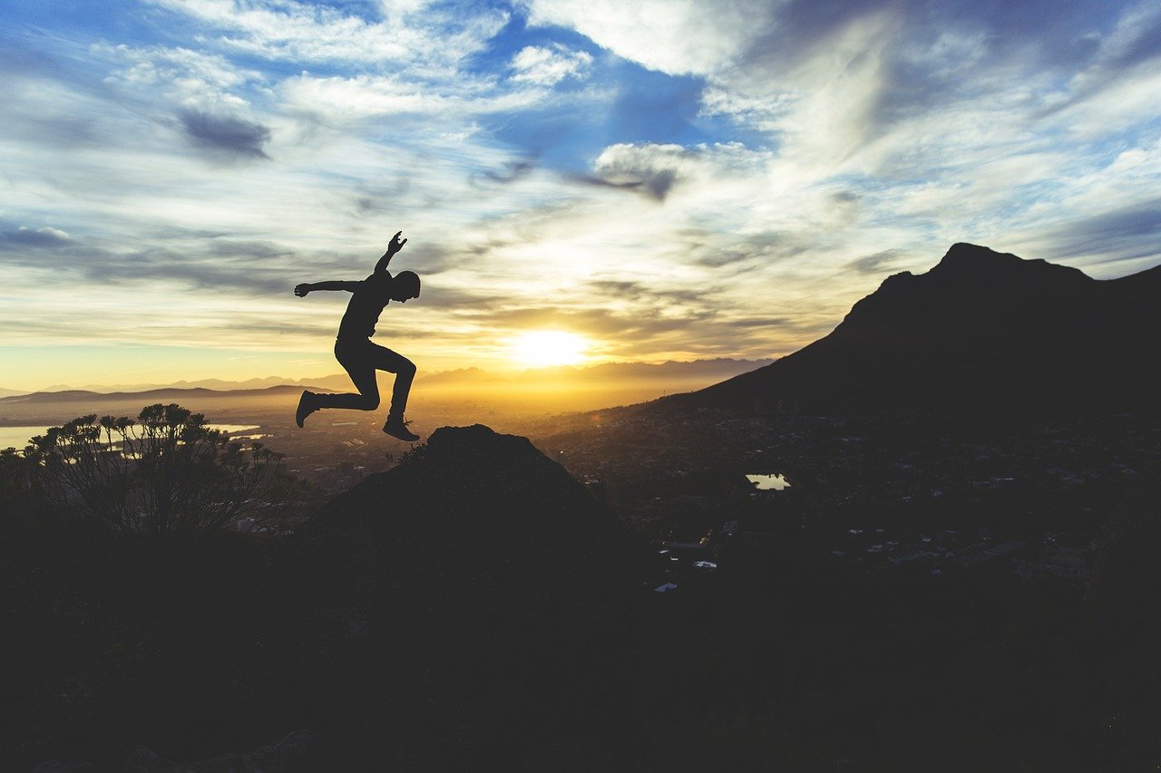 person jumping in the sunset