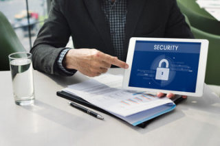 man holding security lock shown on iPad screen