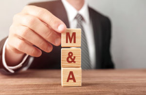 Man stacking wood blocks labeled M&A