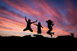 kids jumping in air during sunset